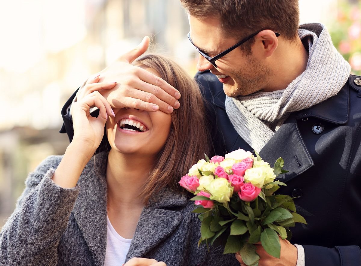 muskarac poklanja cvece devojci