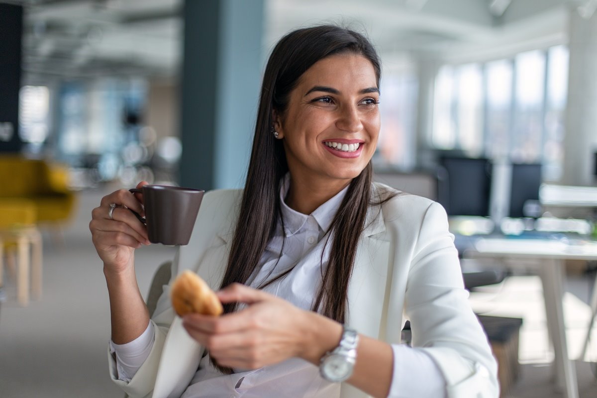 Žena jede kroasan za doručak