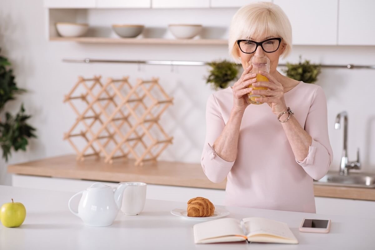 Žena pije sok od pomorandže