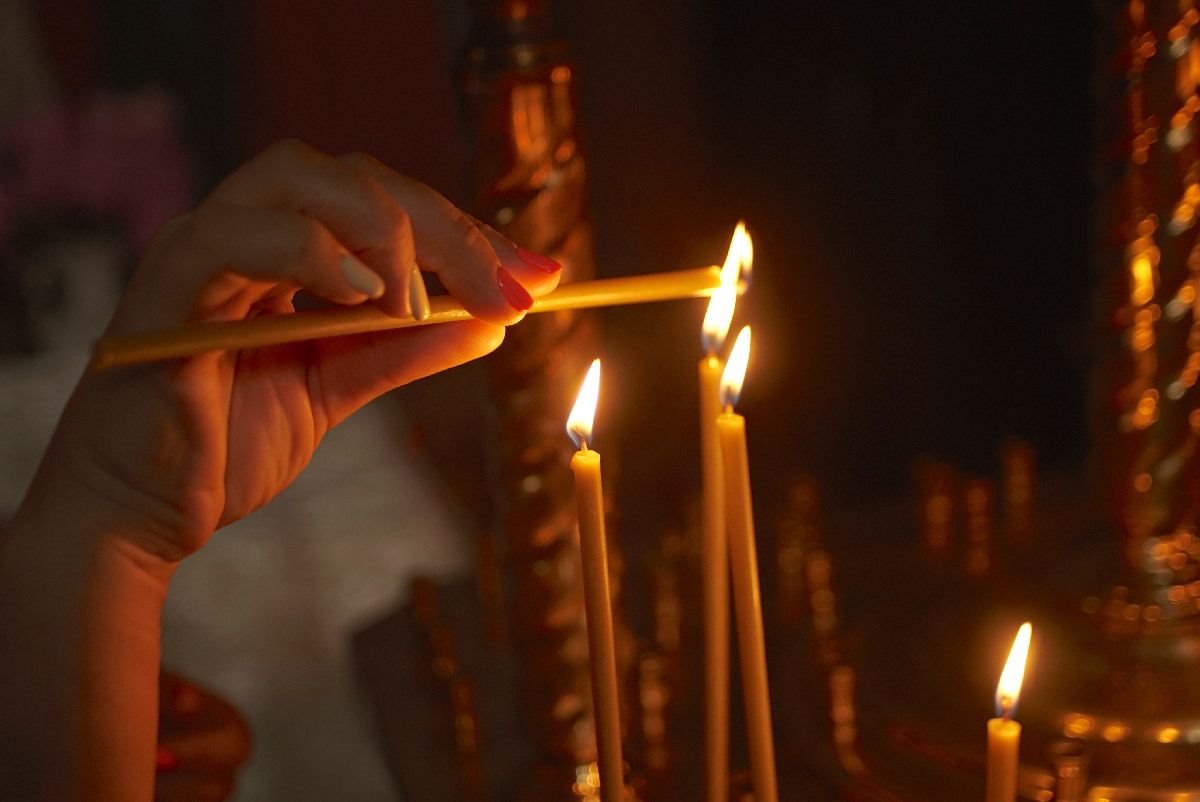 zena pali svecu u crkvi.jpg