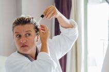 Žena neguje kosu uljem od amle