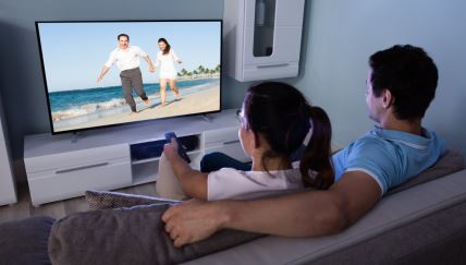 Par gleda televizor u dnevnoj sobi