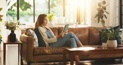 Žena ćita knjigu u dnevnoj sobi