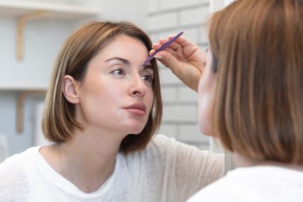 Žena sređuje obrve