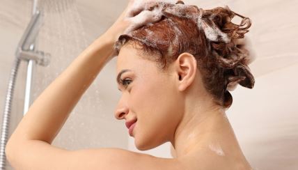 žena pere kosu šamponom